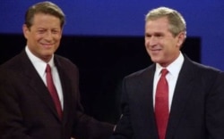 Capres AS dari Partai Demokrat Al Gore (kiri) dan Capres dari Partai Republik, George W. Bush berjabat tangan sebelum debat presiden pertama pada tahun 2000. (Foto: dok).