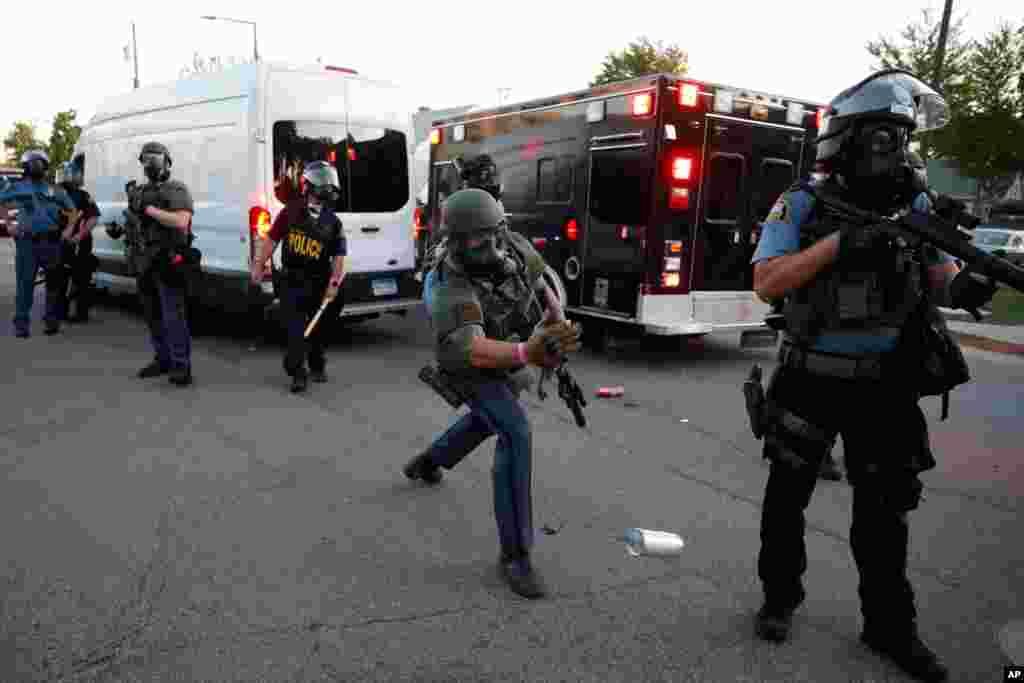 A member of the Minnesota State Police tosses a can of teargas down a street, May 28, 2020, in St. Paul, Minn.