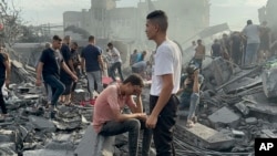 FILE - Palestinians look for survivors following an Israeli airstrike in Nusseirat refugee camp, Gaza Strip, Oct. 31, 2023. Aid for 2.7 million people in Gaza and the West Bank will cost $1.2 billion, a U.N. humanitarian office spokesman said November 3.