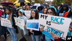 FILE - People rally as the Supreme Court hears oral arguments on two cases that could decide the future of affirmative action in college admissions, in Washington, Oct. 31, 2022. 