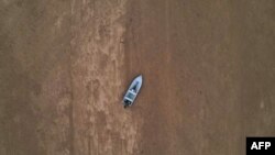 FILE - A boat is seen stranded on the dry riverbed of the Pahang river in Chenor, Malaysia's Pahang state, Aug. 10, 2023.