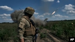 FILE - Seorang tentara Ukraina menyaksikan sistem peluncuran roket ganda Grad menembakkan peluru di dekat Bakhmut, wilayah Donetsk, Ukraina, 13 Agustus 2023.