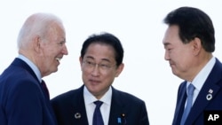 FILE - President Joe Biden, left, talks with Japan's Prime Minister Fumio Kishida and South Korean President Yoon Suk Yeol, right, ahead of a trilateral meeting on the sidelines of the G7 Summit in Hiroshima, Japan, May 21, 2023. 