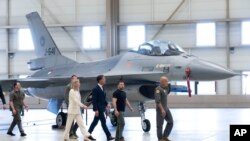 Ukrainian President Volodymyr Zelenskyy, second right, and Dutch caretaker Prime Minister Mark Rutte, center, look at F-16 fighter jets in Eindhoven, Netherlands, Aug. 20, 2023. 