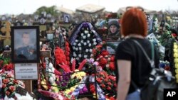 Росіянка біля м.Волгоград, Росія, відвідує цвинтар, де поховані російські солдати, які загинули на війні Росії проти України, травень 2022 року. Фото: АР