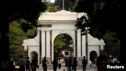 FILE = People walk near the gate of Tsinghua University in Beijing, July 27, 2016. 
