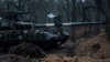 A Ukrainian serviceman smokes a cigarette while standing on top of a tank near Bakhmut, Ukraine, March 8, 2023. 