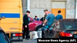 Tim investigasi tampak memeriksa lokasi jatuhnya drone asal Ukraina di Krasnogorsk, di luar Kota Moscow, Rusia, pada 22 Agustus 2023. (Foto: Moscow News Agency via AP)
