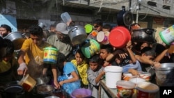 Palestinians crowded together as they wait for food distribution in Rafah, southern Gaza Strip, Nov. 8, 2023.