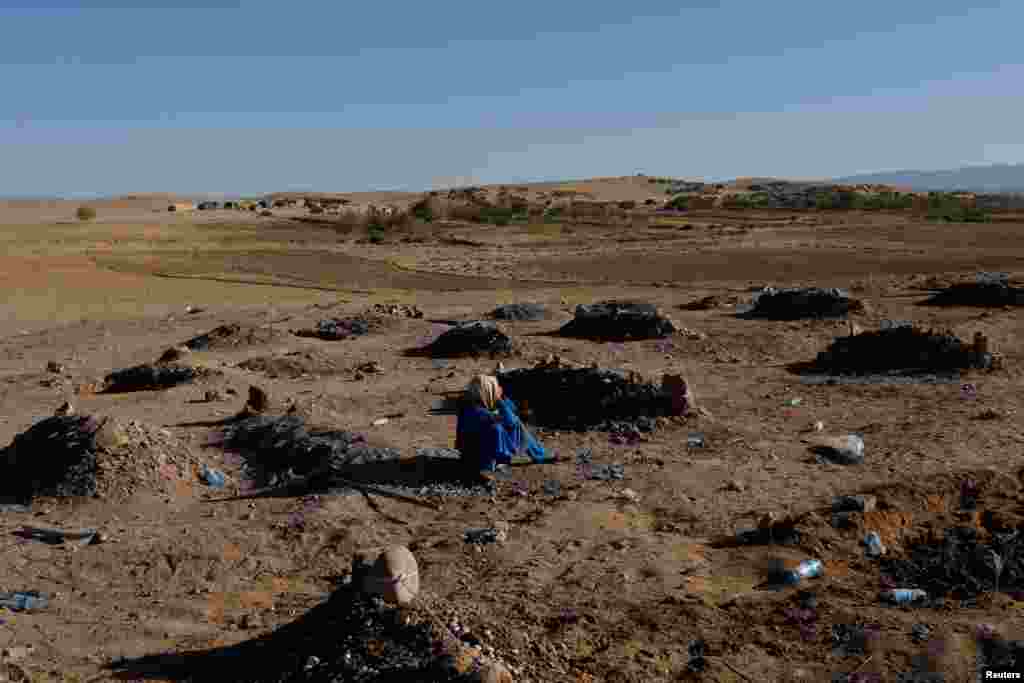 An Afghan girl cries over her mother's grave in a cemetery for victims of the recent earthquake in the district of Zinda Jan, in Herat, Afghanistan, Oct. 9, 2023. REUTERS/Ali Khara