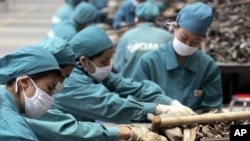 Chinese workers sellect car part scrap to collect aluminum for recycling at a smelting plant Monday, June 6, 2005 in outskirt of Shanghai. China has stopped importing some kinds of recyclable materials.