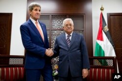 U.S. Secretary of State John Kerry, left, shakes hands with with Palestinian President Mahmoud Abbas at the start of their meeting in the West Bank city of Ramallah, Nov. 24, 2015.