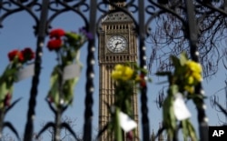 FILE - Floral tributes to the victims of the Westminster terrorist attack are placed outside the Palace of Westminster, London, March 27, 2017.