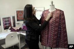 FILE - Designer Natalie Tahhan works on a modern version of the traditional Palestinian thobe in her studio in east Jerusalem, Jan. 29, 2019 photo.