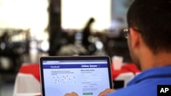 A man demonstrates how he enters his Facebook page as he works on his computer at a restaurant in Brasilia, Brazil, Thursday, Jan. 4, 2018. (AP Photo/Eraldo Peres)