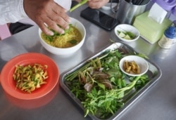 លោក សូផេង មាន​វ័យ៥០ ឆ្នាំ កំពុង​ពិសារ​នំបញ្ចុក​នៅ​ជិត​វត្តបទុមវត្តី​ក្នុង​រាជធានី​ភ្នំពេញ​កាលពី​ថ្ងៃទី៣១ ខែមករា ឆ្នាំ២០២០។ (ផន បុប្ផា/VOA)