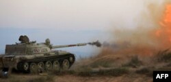 Fighters of Libya's Fajr Libya (Libyan Dawn) militia fire a cannon against a rival militia as they protect a position after they took control of the town of Wershfana, Sept. 29, 2014.