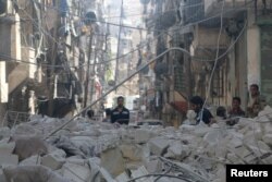 FILE - People inspect a site hit by an airstrike in the rebel-held area of Aleppo's al-Sukari district, Syria, May 30, 2016.