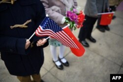 Children hold national flags before the arrival of China's President Xi Jinping and U.S. President Donald Trump during a welcome ceremony at the Great Hall of the People in Beijing, Nov. 9, 2017.