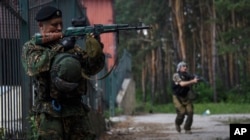 FILE - Russian-backed rebels guard their position near Marinka in the suburbs of Donetsk, eastern Ukraine, June 4, 2015.