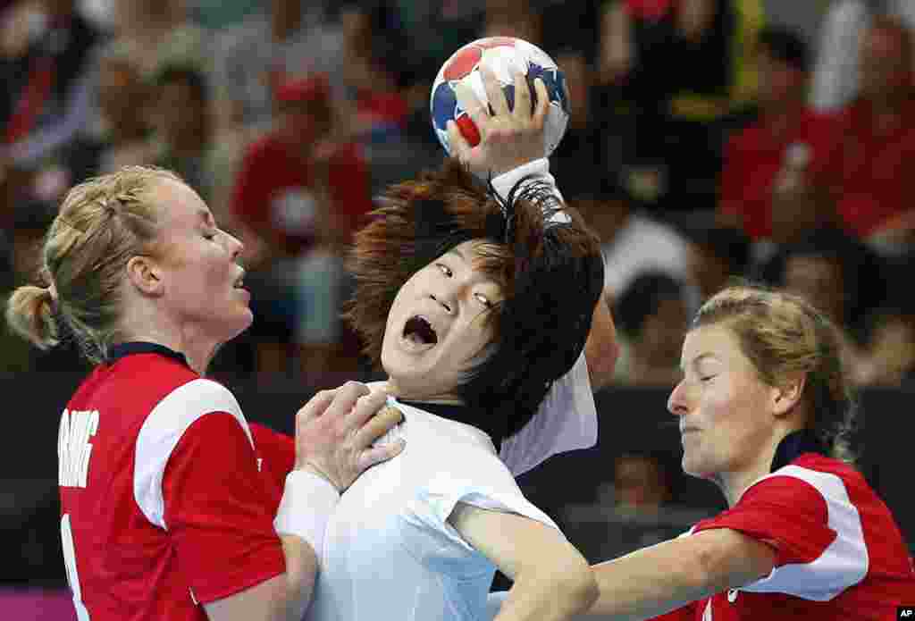 South Korea's Jo Hyo-bi, center is tackled by Norway's Karoline Dyhre Breivang, left, and Lynn-Kristin Koren, right, during their women's handball preliminary match at the 2012 Summer Olympics, Aug. 1, 2012, in London.