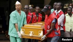 FILE - Mortuary workers and Kenya Red Cross volunteers carry the coffin containing the body of Mildred Yondo, a student killed during an attack by gunmen at Garissa University, from the Chiromo Mortuary in the capital Nairobi, April 8, 2015.