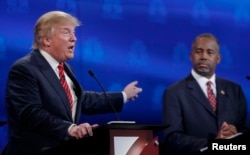 FILE - U.S. presidential candidate and businessman Donald Trump, left, speaks as Ben Carson, a retired neurosurgeon, listens at the 2016 U.S. Republican presidential candidates debate held by CNBC in Boulder, Colo., Oct. 28, 2015.