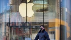 A man wears a face mask as he walks past an Apple store that is temporarily closed due to health concerns in Beijing, Tuesday, Feb. 4, 2020. Apple announced that it will temporarily close all of its stores in China due to a virus outbreak. (AP Photo/Mark