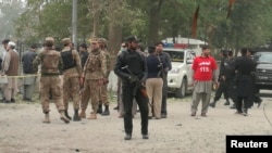 A policeman stands guard at the scene of a bomb attack in Peshawar, Pakistan, Feb. 15, 2017.