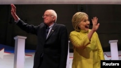 Democratic U.S. presidential candidates Senator Bernie Sanders and former Secretary of State Hillary Clinton arrive on stage ahead of the start of the PBS NewsHour Democratic presidential candidates debate in Milwaukee, Wisconsin, Feb. 11, 2016.