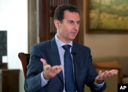 In this Wednesday, Sept. 21, 2016 photo released by the Syrian Presidency, Syrian President Bashar Assad speaks to The Associated Press at the presidential palace in Damascus, Syria.