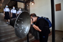 Seorang pria mengambil foto pengeras suara yang dilubangi peluru selama pembantaian Universitas Thammasat pada 6 Oktober 1976, pada pameran memperingati peristiwa di Universitas Thammasat di Bangkok pada 6 Oktober 2020. (Foto: AFP)