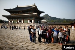 FILE - Chinese tourists pose for a group photo at the Gyeongbok Palace in central Seoul, South Korea, Oct. 5, 2016.