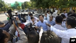 Rong Chhun, rear center, Cambodian Teacher Independence Association's president gives a press conference on a street as he walking to the protesting site to mark the two-year anniversary of Thai troop crossing border in Phnom Penh, Thursday, July 15, 2010.