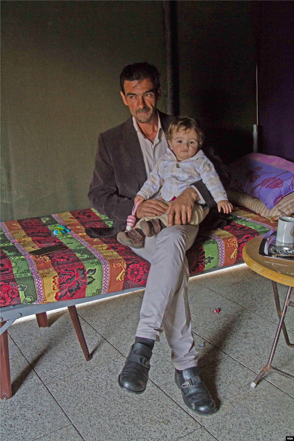 Hussein Youssef with his grandson. The boy’s father, Mohammad Youssef, is among those taken captive by the Islamic State militants and the al-Nusra Front. (John Owens/VOA)