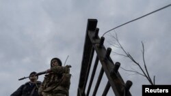 A service member of the Ukrainian armed forces stands by the only escape route used by locals to evacuate from the town of Irpin, after days of heavy shelling, while Russian troops advance towards the capital, March 7, 2022.