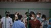 Angry residents confront officials from behind a fence erected in a neighborhood compound in the Xuhui district of Shanghai on June 6, 2022.