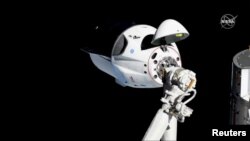 FILE - The SpaceX Crew Dragon capsule approaches the International Space Station, March 3, 2019.