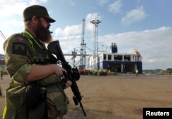 FILE - A Norwegian soldier stands guard as German military equipment is unloaded at Fredrikstad, Norway, Sept. 7, 2018.