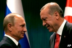 FILE - Turkish President Recep Tayyip Erdogan, right, shakes hands with Russian President Vladimir Putin in Ankara, Turkey, Sept. 28, 2017.