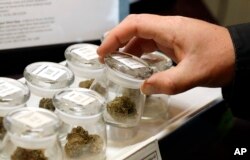 FILE - Different strains of marijuana are displayed for sale at the Warmland Centre, a medical marijuana dispensary in Mill Bay, British Columbia on Vancouver Island in Canada, Sept. 24, 2018.