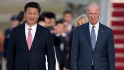 Chinese President Xi Jinping and Vice President Joe Biden walk down the red carpet on the tarmac during an arrival ceremony in Andrews Air Force Base, Md., Thursday, Sept. 24, 2015.
