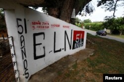 FILE - Graffiti of rebel group National Liberation Army (ELN) is seen at the entrance of the cemetery of El Palo, Cauca, Colombia, Feb. 10, 2016.