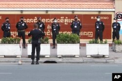 រូបឯកសារ៖ មន្ត្រីប៉ូលិសកម្ពុជាឈរនៅមុខសាលាដំបូងរាជធានីភ្នំពេញ នៅមុនសវនាការរបស់លោក រ៉ុង ឈុន ប្រធានសហភាពសហជីពកម្ពុជា នៅរាជធានីភ្នំពេញ កាលពីថ្ងៃទី ១៨ ខែសីហា ឆ្នាំ ២០២១។