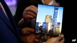 In this file photo, a man holds a new Huawei Mate X foldable 5G smartphone during the Mobile World Congress wireless show, in Barcelona, Spain, Feb. 26, 2019.