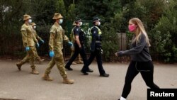 Petugas ADF dan polisi Victoria melakukan patroli saat diberlakukannya pembatasan di Melbourne, Australia, 26 Juli 2020. (AAP Image/Daniel Pockett via Reuters) 