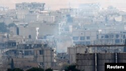 Smoke rises from central Kobani during fighting between Islamic State militants and Kurdish forces, as seen from the Turkish side of the Turkey-Syria border, Nov. 24, 2014. 