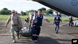 Soldiers and health brigade members carry equipment from a plane to be used in areas affected by an earthquake in Yurimaguas, Peru, May 26, 2019