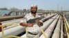 FILE - A security guard keeps watch over oil pipelines in Aramco refinery in Saudi Arabia.