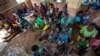 FILE - In this Dec. 11, 2019 file photo, residents of the Malawi village of Tomali wait to have their young children become test subjects for the world's first vaccine against malaria in a pilot program.